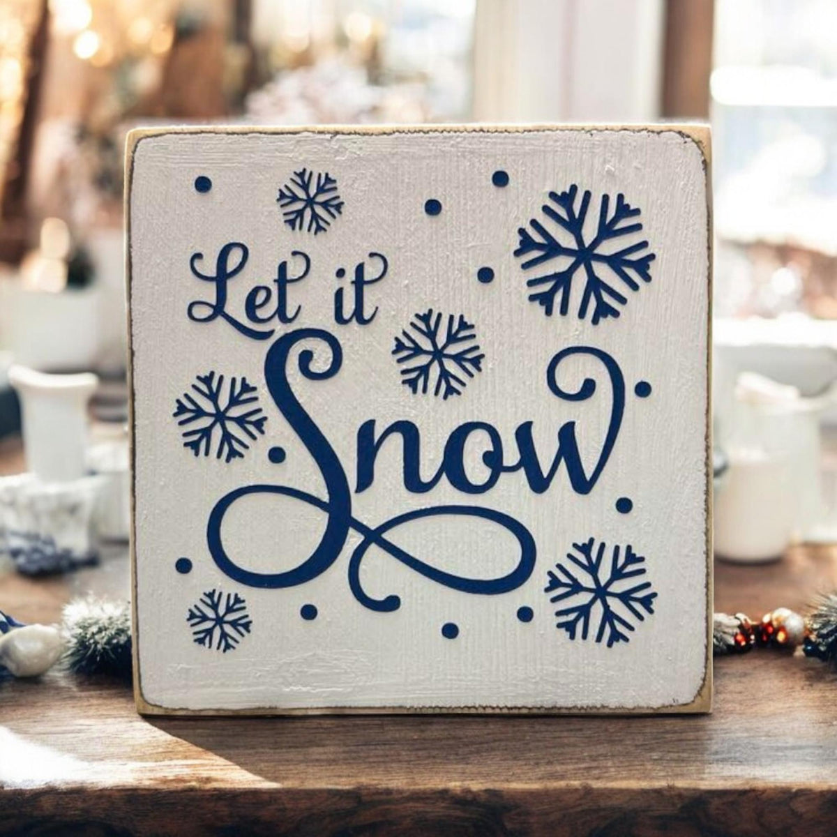 Let It Snow sign close up showing navy snowflake details and distressed finish