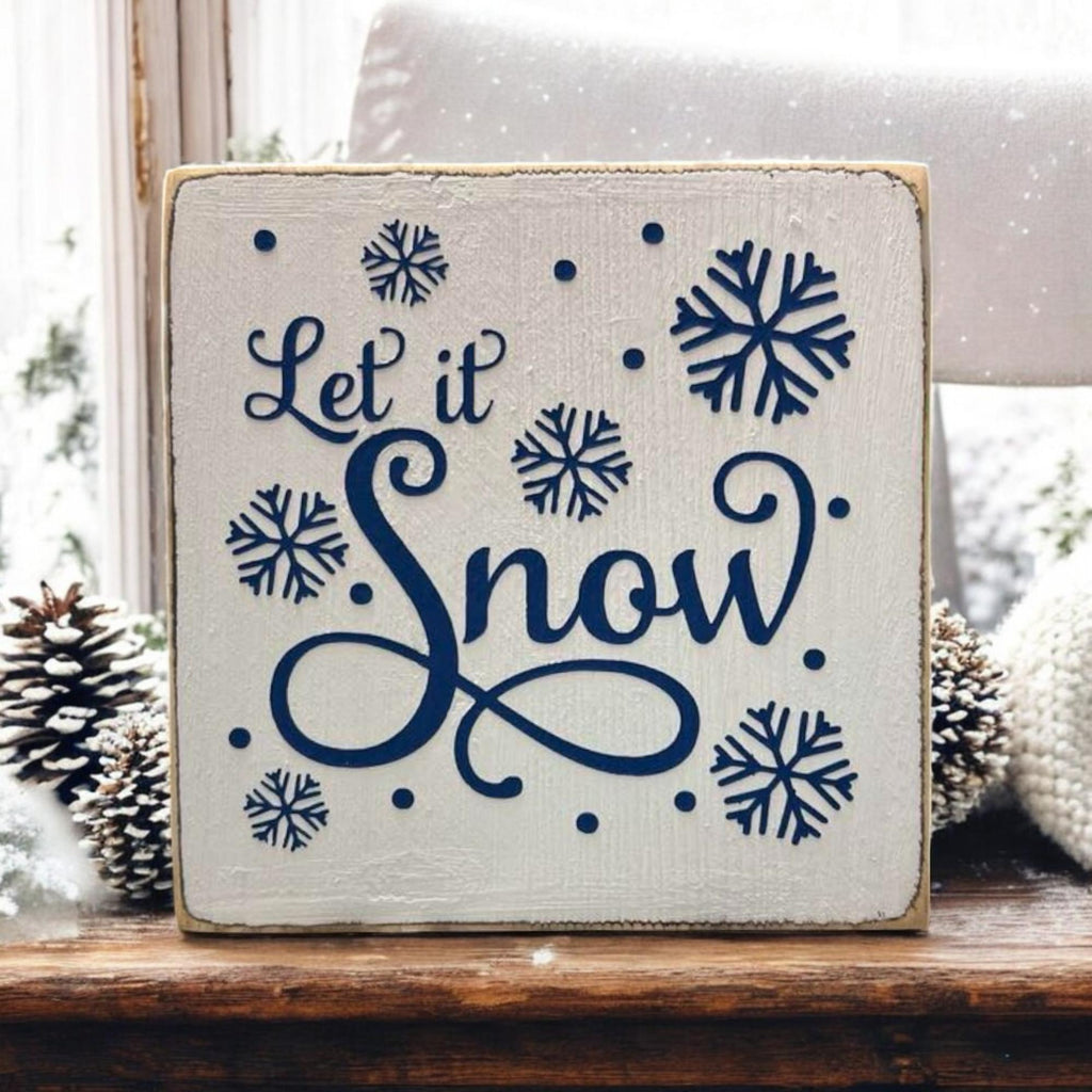 Let It Snow sign on kitchen counter with candles and dried botanicals