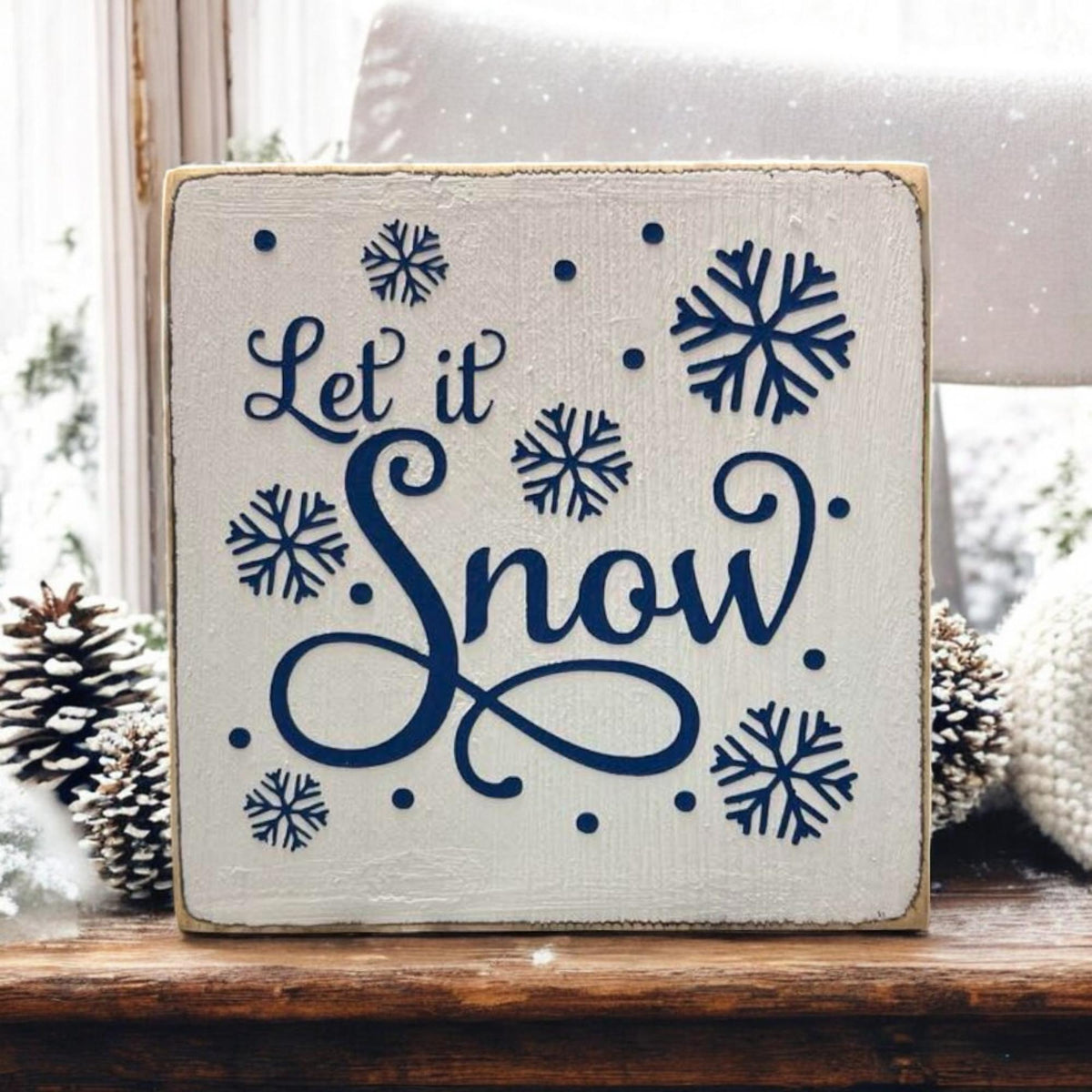 Let It Snow sign on kitchen counter with candles and dried botanicals