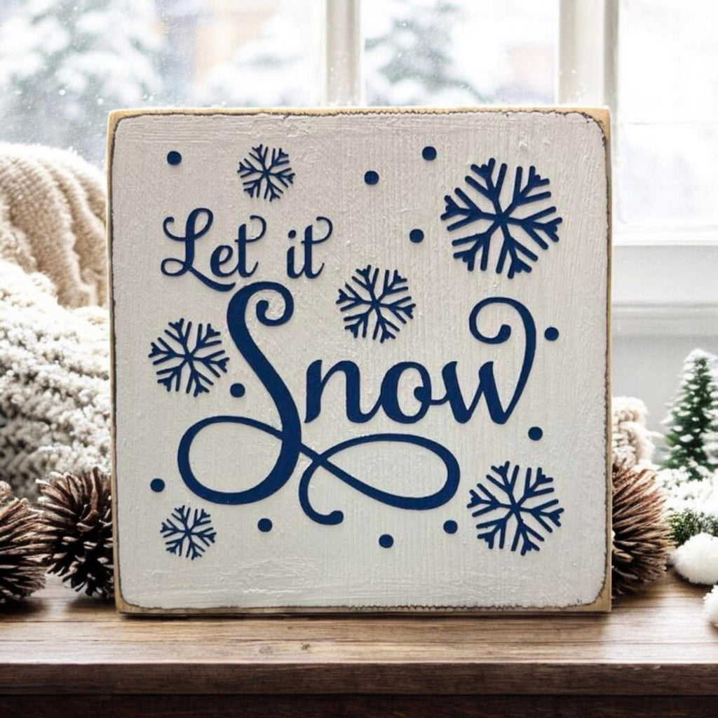 Let It Snow sign front view on rustic wood with winter greenery