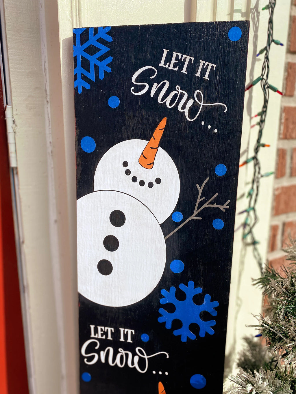 Let It Snow porch leaner sign close up showing top snowman with carrot nose and blue snowflakes detail