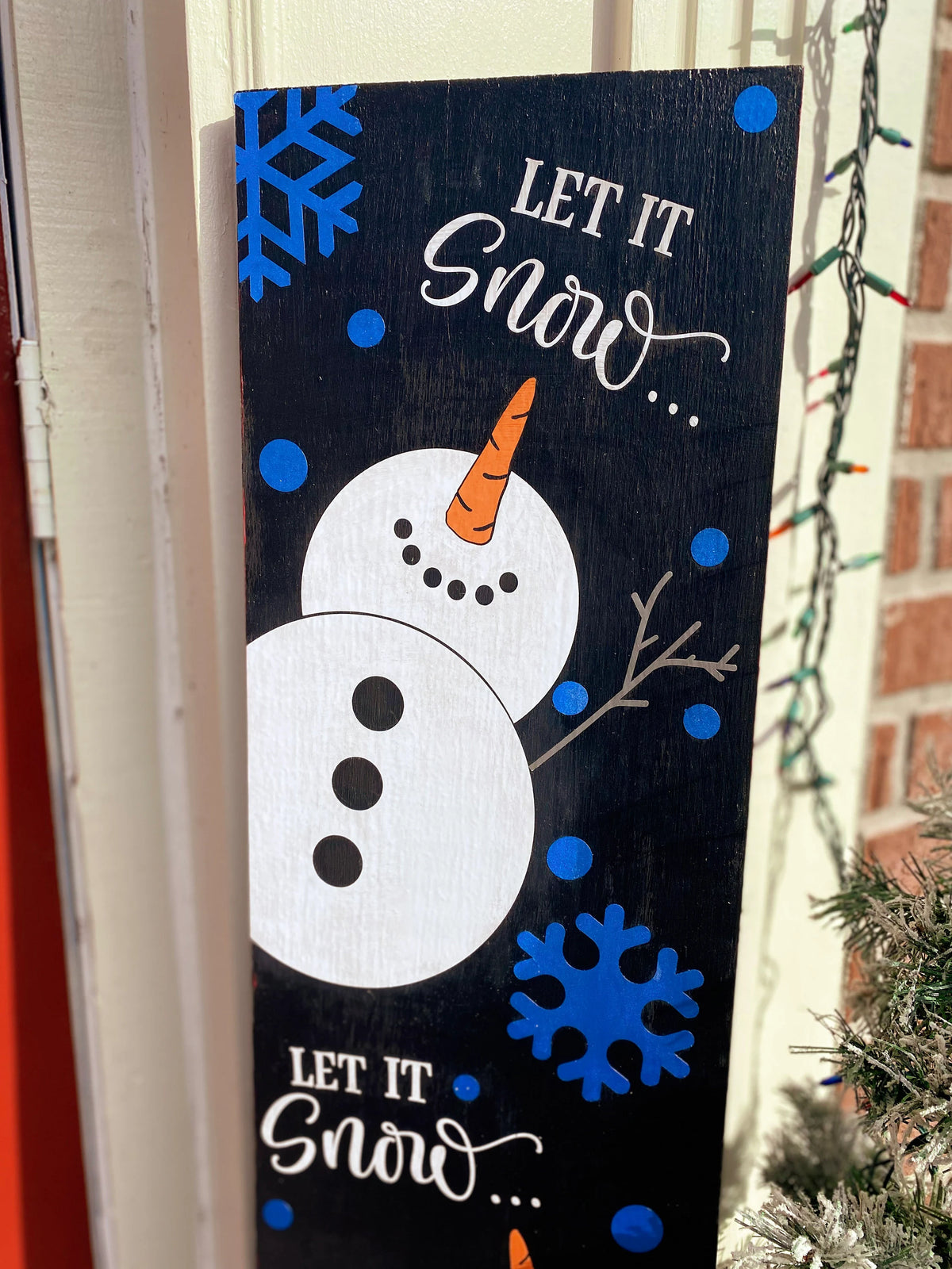 Let It Snow porch leaner sign close up showing top snowman with carrot nose and blue snowflakes detail