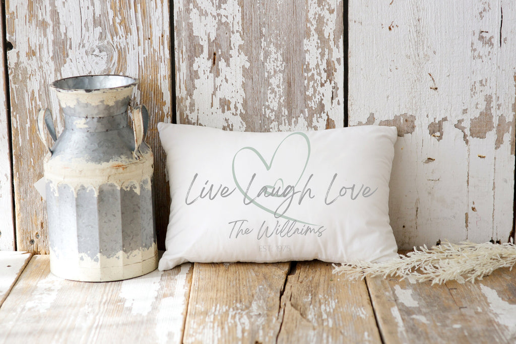 Personalized Live Laugh Love lumbar pillow on cream tufted sofa with gray knit blanket