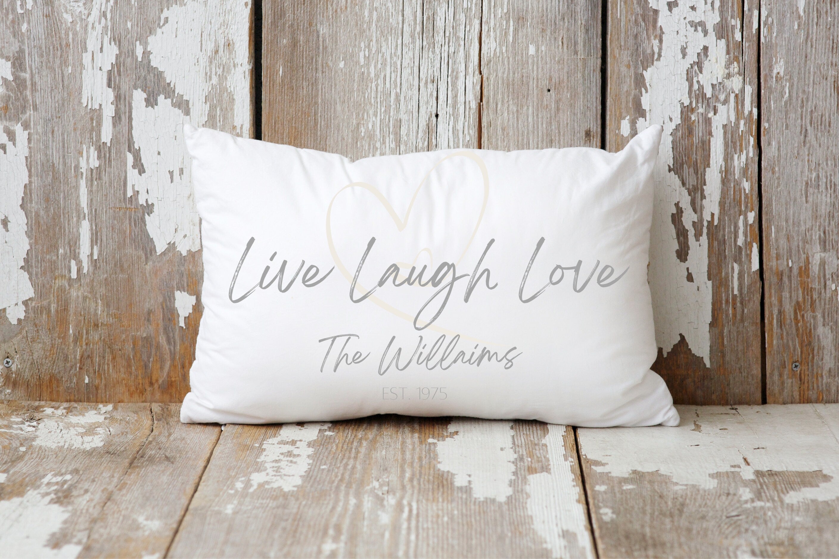 Personalized Live Laugh Love lumbar pillow on cream tufted sofa with white fur blanket