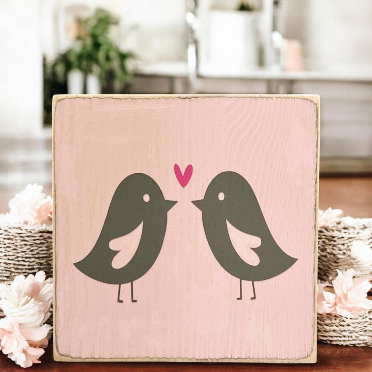 Lovebirds Valentine wood block sign on wood surface with pink and red roses close up