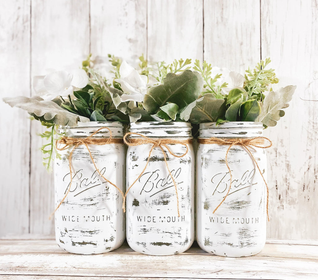 Set of 3 white mason jars with white hydrangeas and mixed greenery on white background