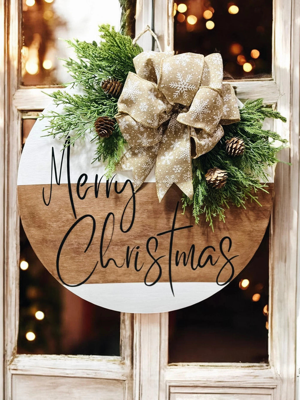 Natural wood and white Merry Christmas round pine door hanger with evergreen branches pinecones and beige snowflake bow product hero shot on white background