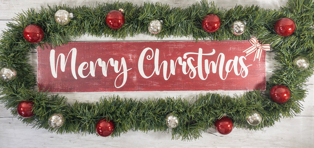 Merry Christmas farmhouse wood sign distressed cranberry red with white script lettering and red white striped bow on white shiplap wall hero shot