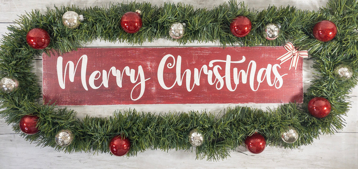 Merry Christmas farmhouse wood sign distressed cranberry red with white script lettering and red white striped bow on white shiplap wall hero shot