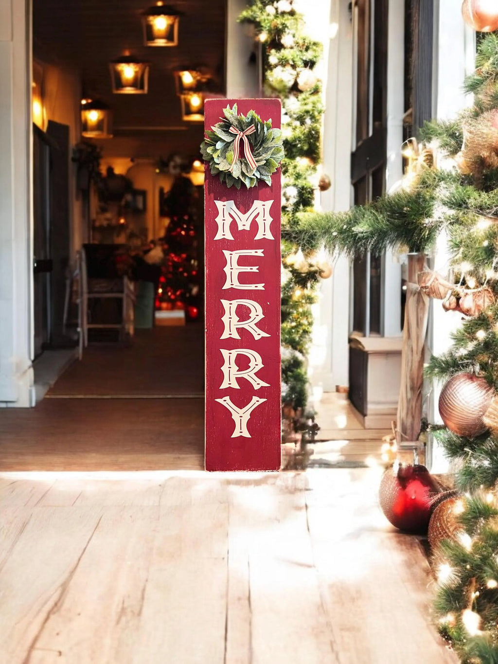 MERRY porch leaner sign with holly wreath leaning against red front door with Christmas greenery and lanterns full view
