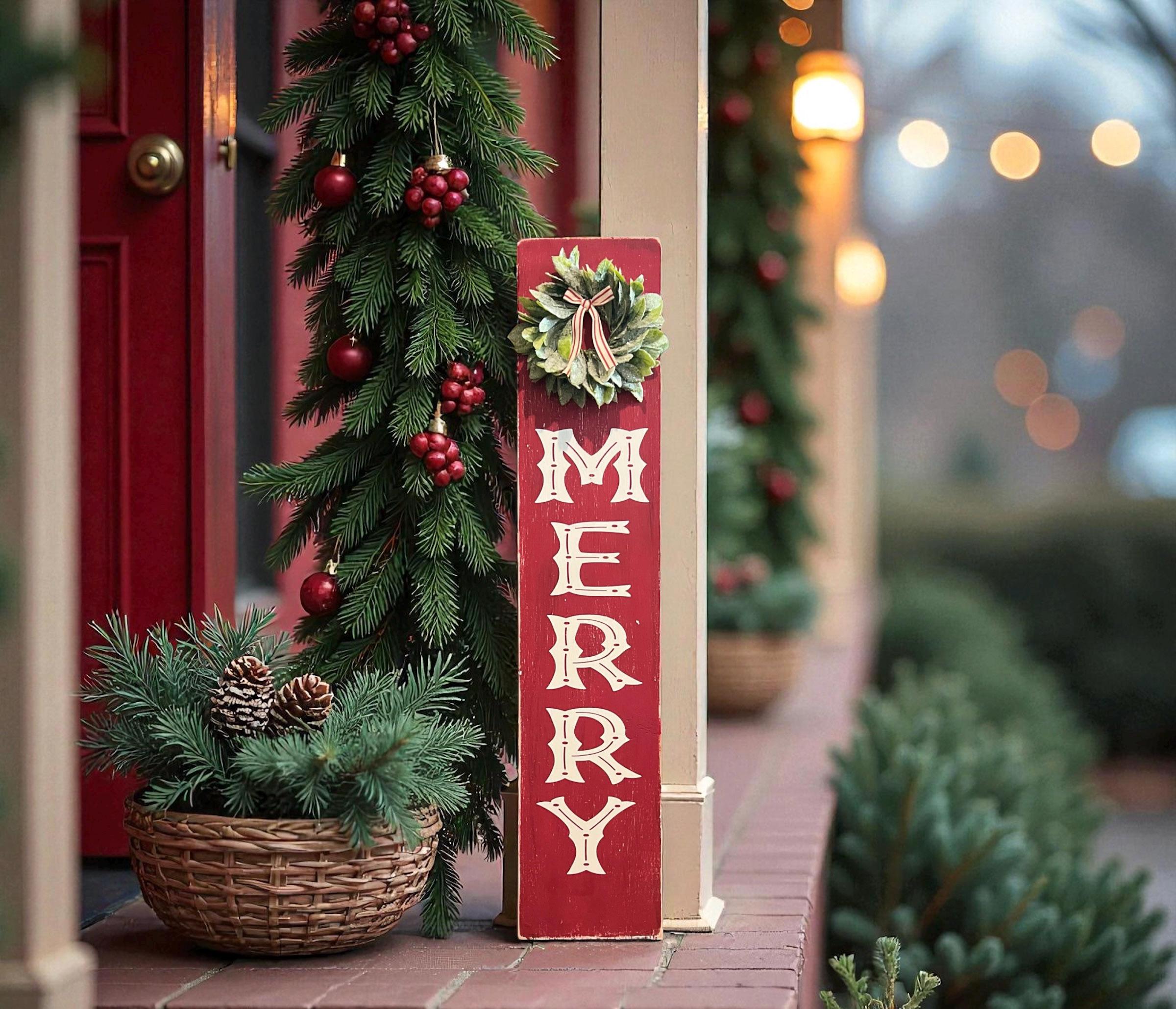 MERRY porch leaner sign with holly wreath leaning against glass door with Christmas garland and ornaments on porch