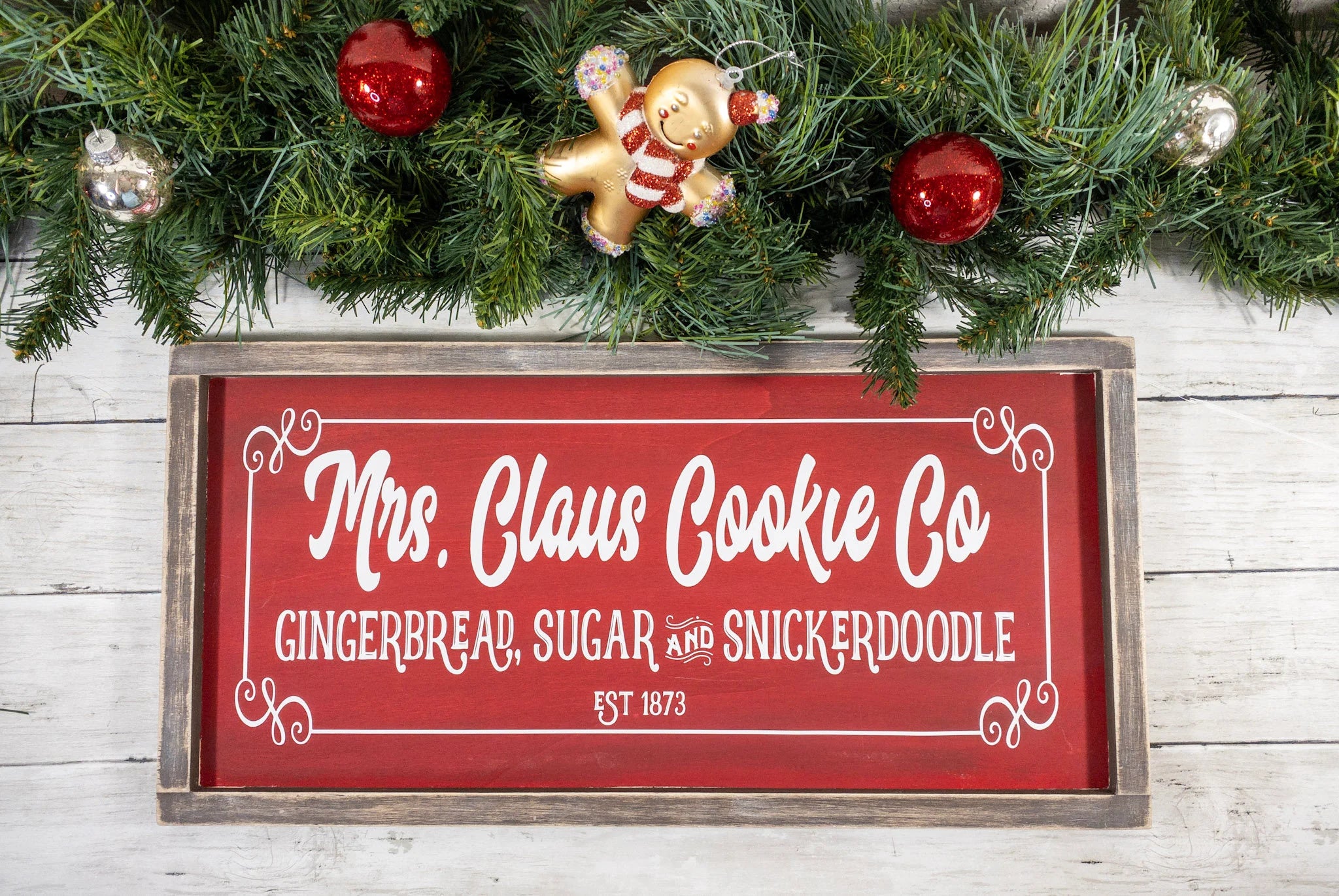 Mrs Claus Cookie Co framed Christmas sign crimson red with white script and serif lettering in distressed gray wood frame product hero shot on white background
