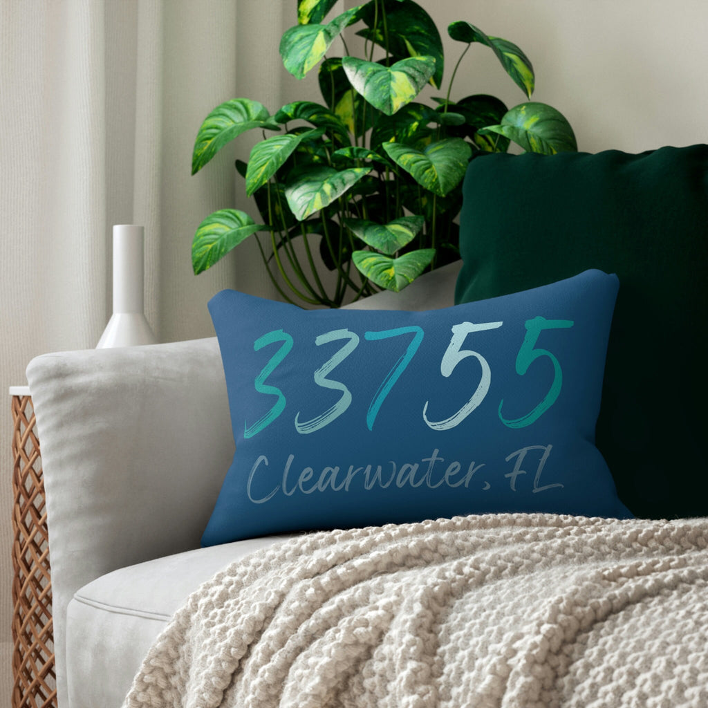 Personalized 33755 Clearwater FL navy lumbar pillow on white wicker chair with cream knit blanket close up