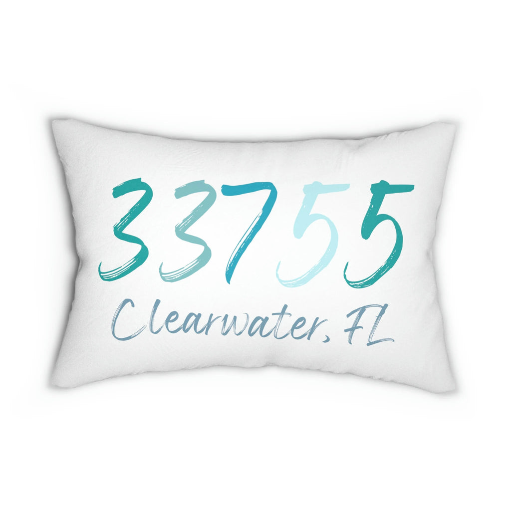 Personalized zip code lumbar pillow reading 33755 Clearwater FL in coastal teal blues on white distressed wood chair