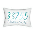 Personalized zip code lumbar pillow reading 33755 Clearwater FL in coastal teal blues on white distressed wood chair