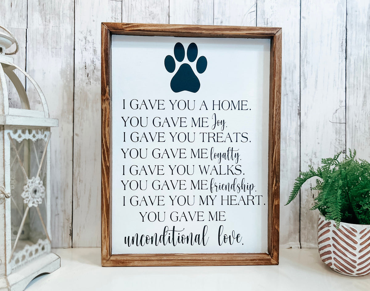 Personalized pet memorial sign with dark navy paw print angled view with white lantern and green plant