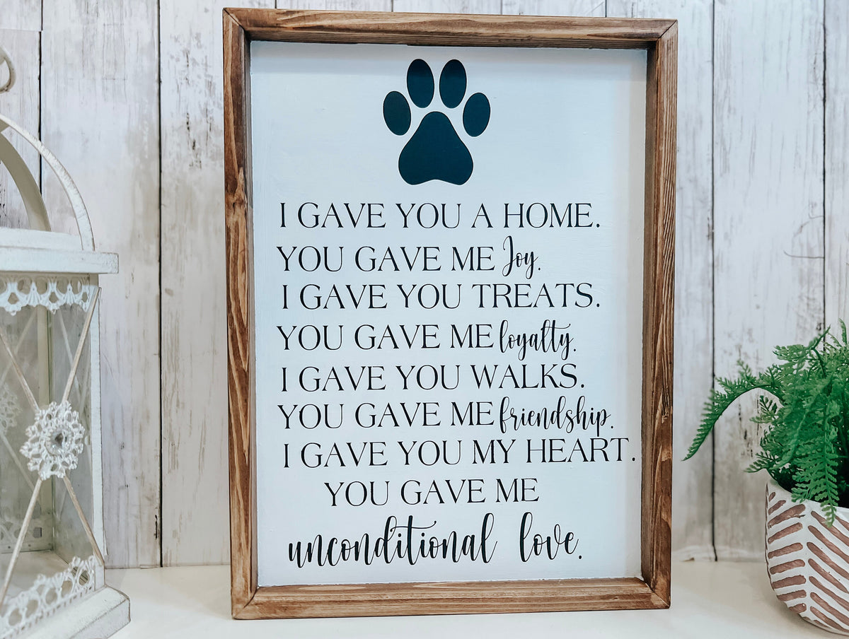 Personalized pet memorial sign with dark navy paw print and unconditional love lettering on white background with dark walnut frame