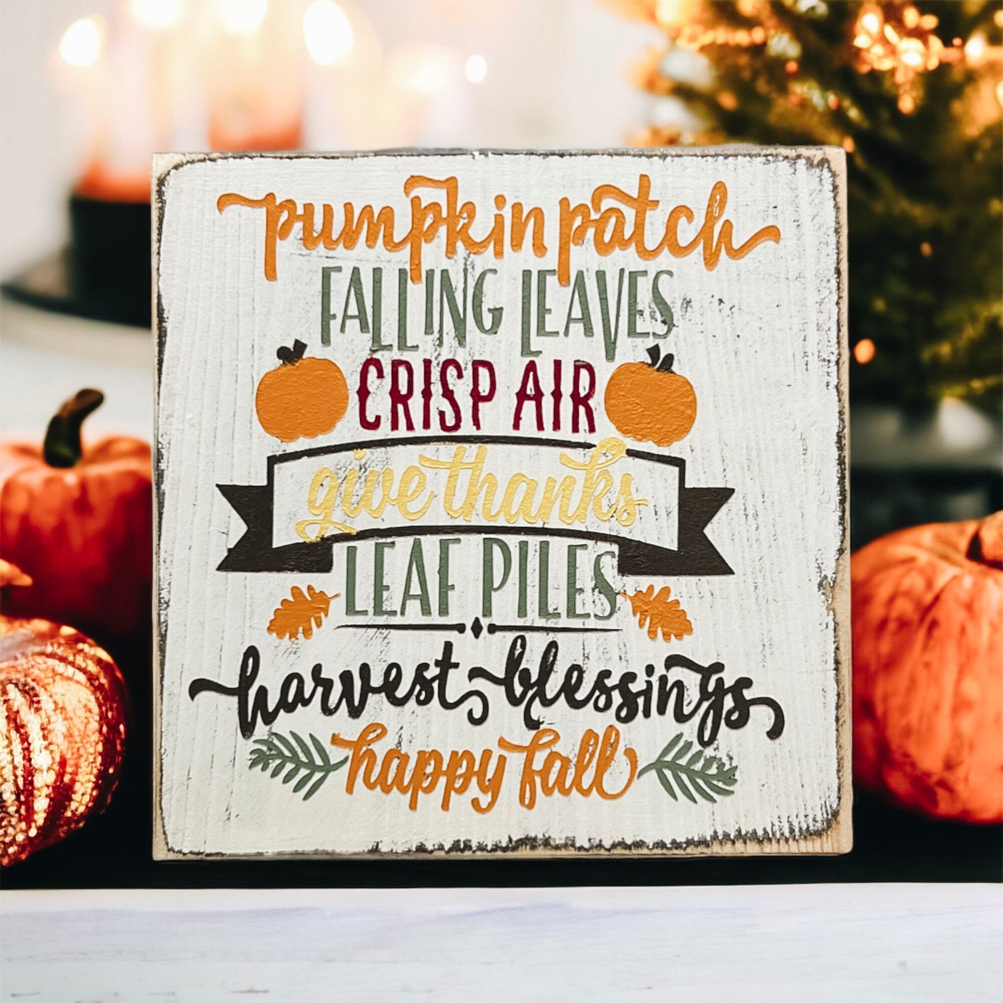 Fall sign on rustic wood surface with autumn leaves and cozy textile
