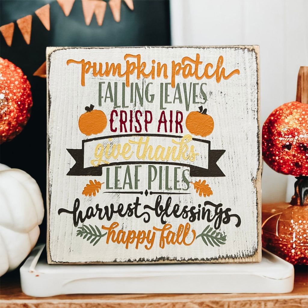 Fall sign on marble surface with orange glitter pumpkins and holiday lights