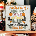 Fall sign on weathered wood deck surrounded by colorful autumn leaves