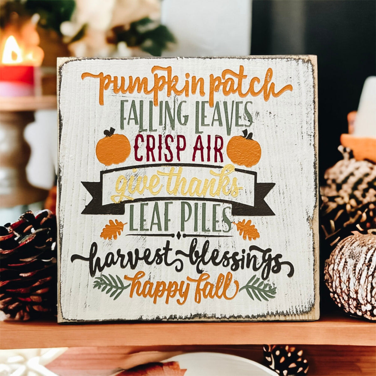 Fall sign on weathered wood deck surrounded by colorful autumn leaves