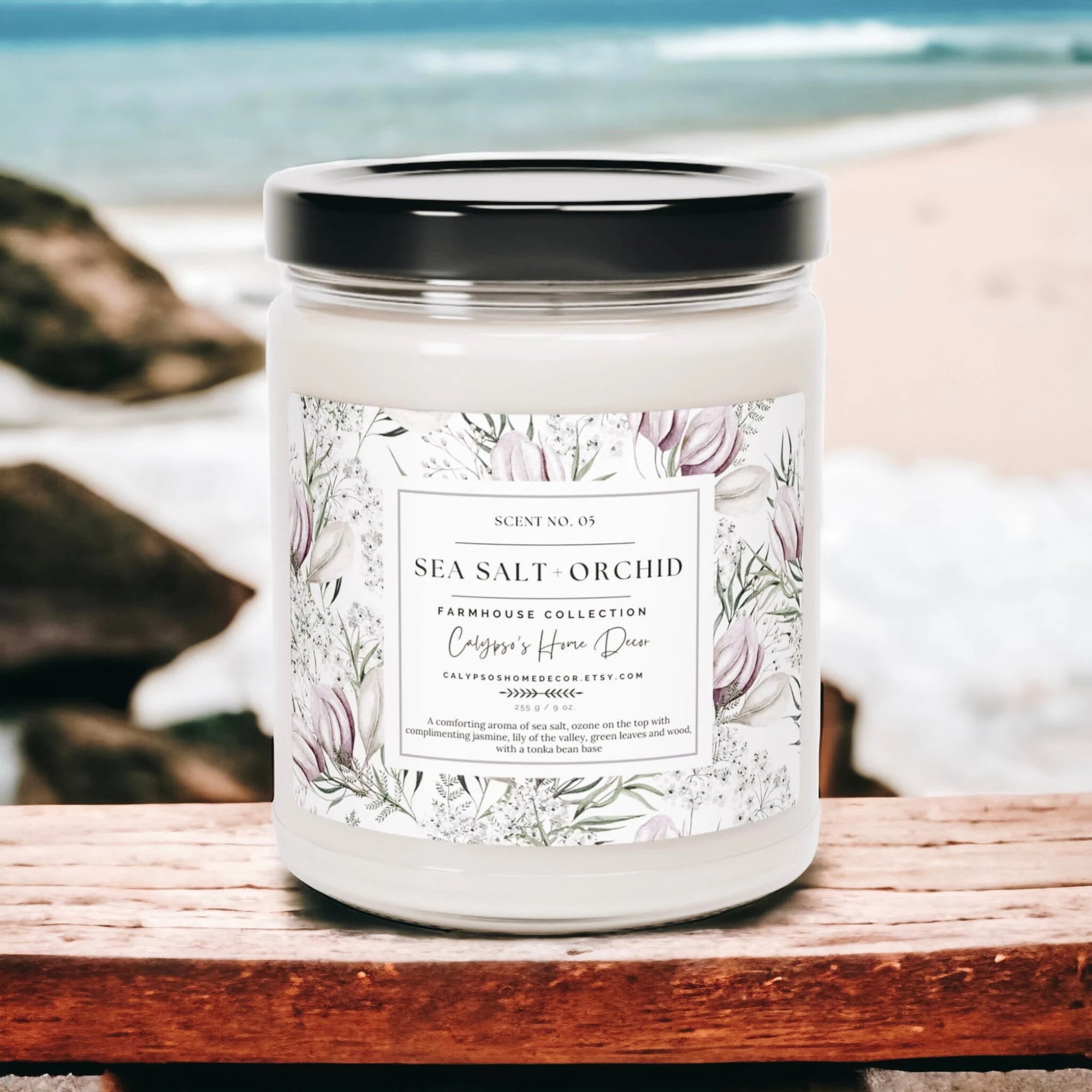 Sea Salt Orchid candle on wood surface with wicker basket and white flowers in background