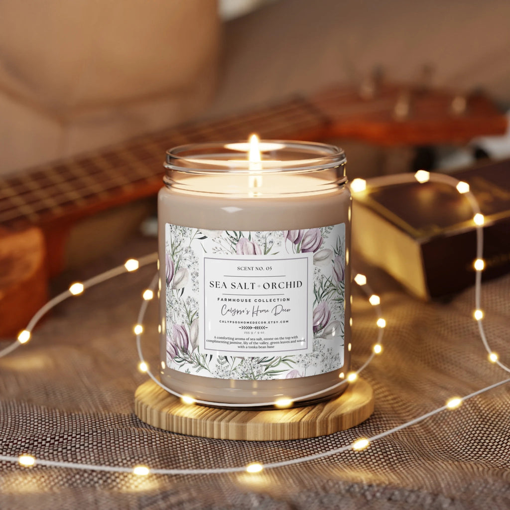 Sea Salt Orchid candle on rustic wood surface with ocean waves and rocks in background