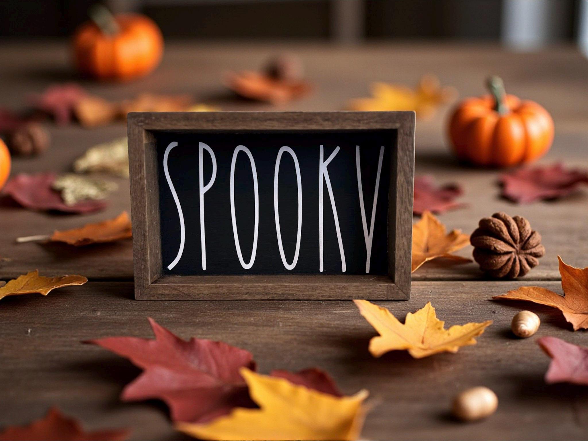 Spooky black sign close up with white lettering on dark wood surface