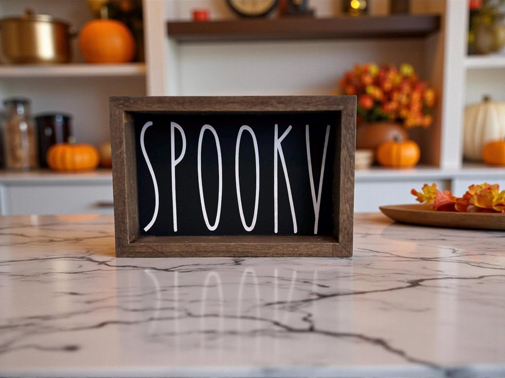Spooky black sign flanked by glowing jack-o-lanterns in dark attic setting