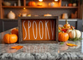 Spooky orange wood sign with dark frame on rustic wood with fall leaves and pumpkins