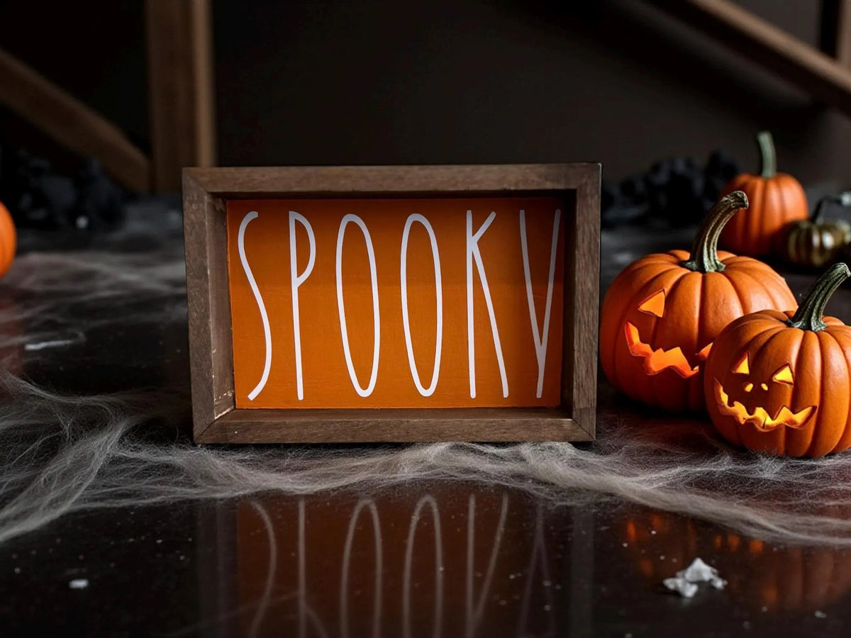 Spooky sign styled with mini pumpkins and fall foliage
