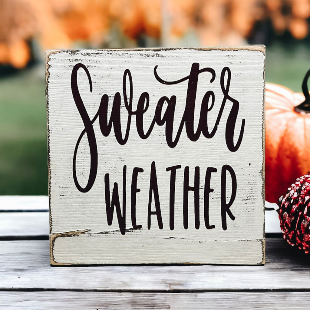 Sweater Weather sign on white tray with ornament and pumpkin