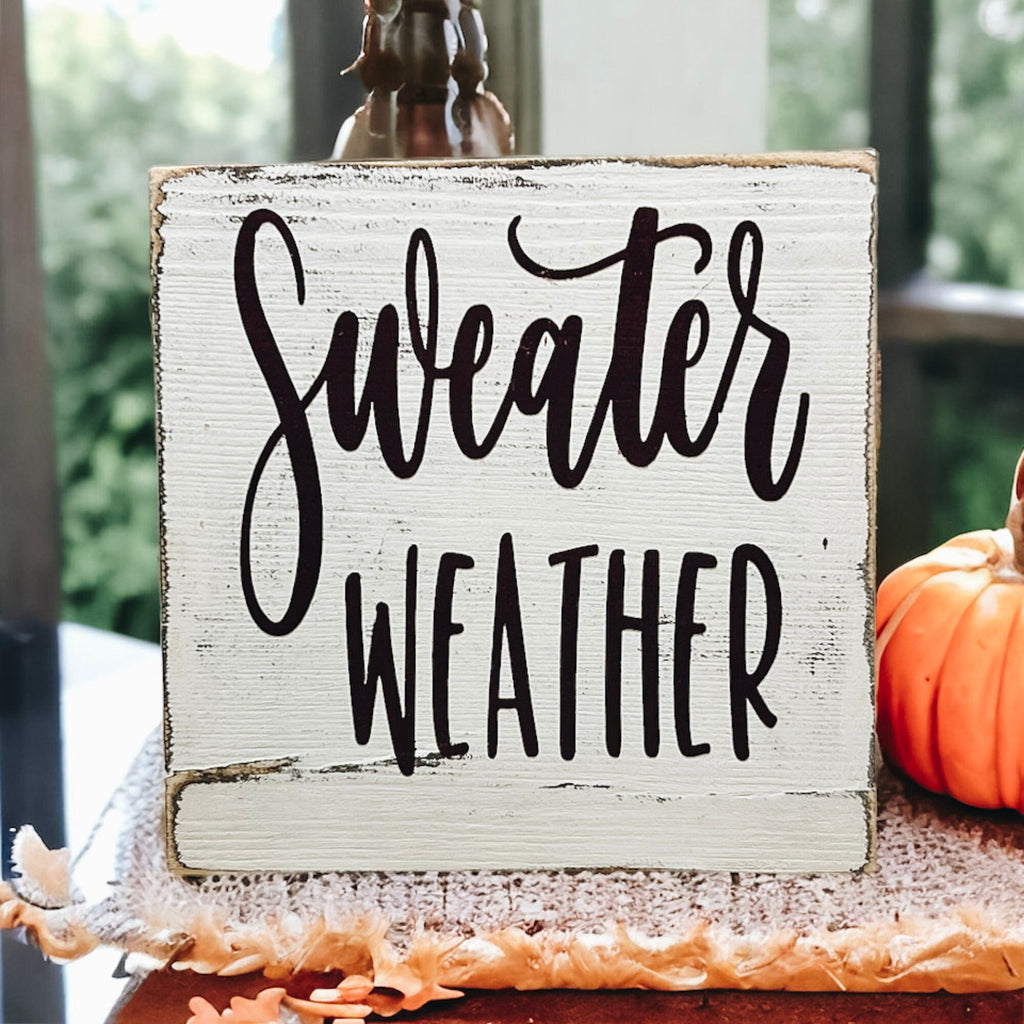 Sweater Weather sign in burgundy lettering on tiered tray with pumpkins