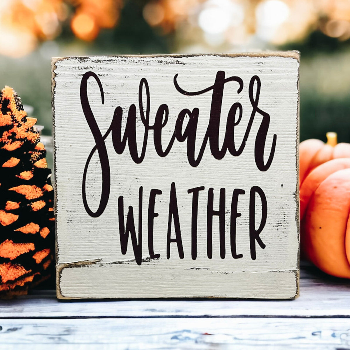 Sweater Weather sign front view on wood surface
