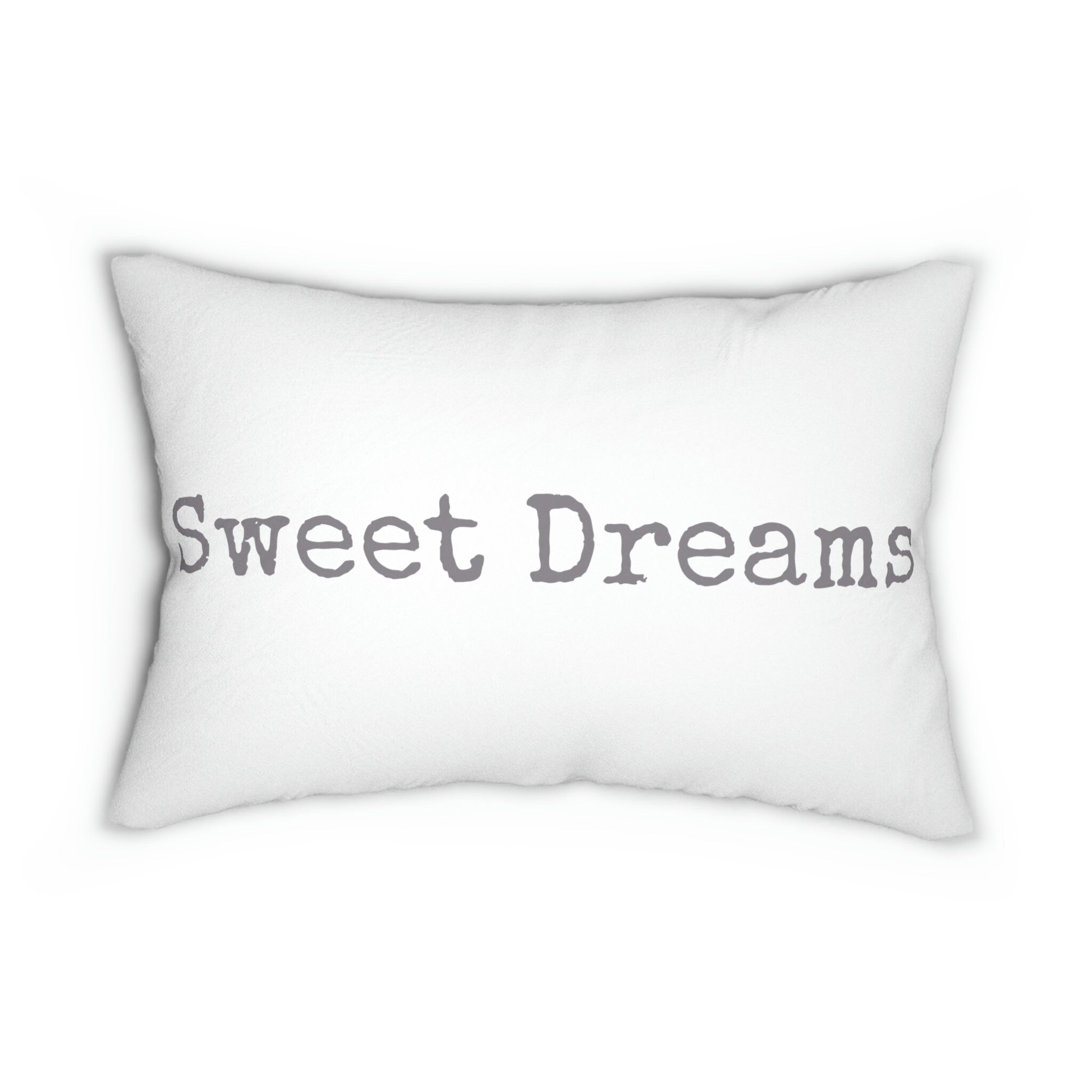 Sweet Dreams white lumbar pillow with gray distressed typewriter lettering on cream upholstered sofa lifestyle shot