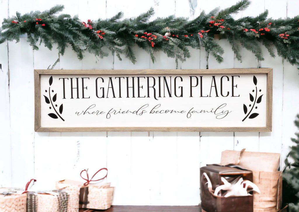 The Gathering Place where friends become family framed farmhouse sign on white shiplap wall above rustic wood console table with wicker basket and greenery