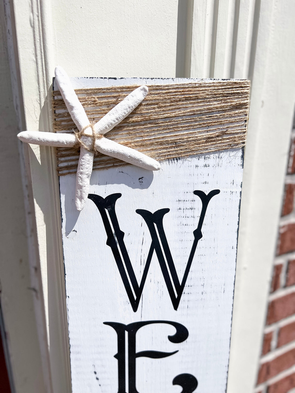 Crab Welcome porch leaner full view on white door with brick wall