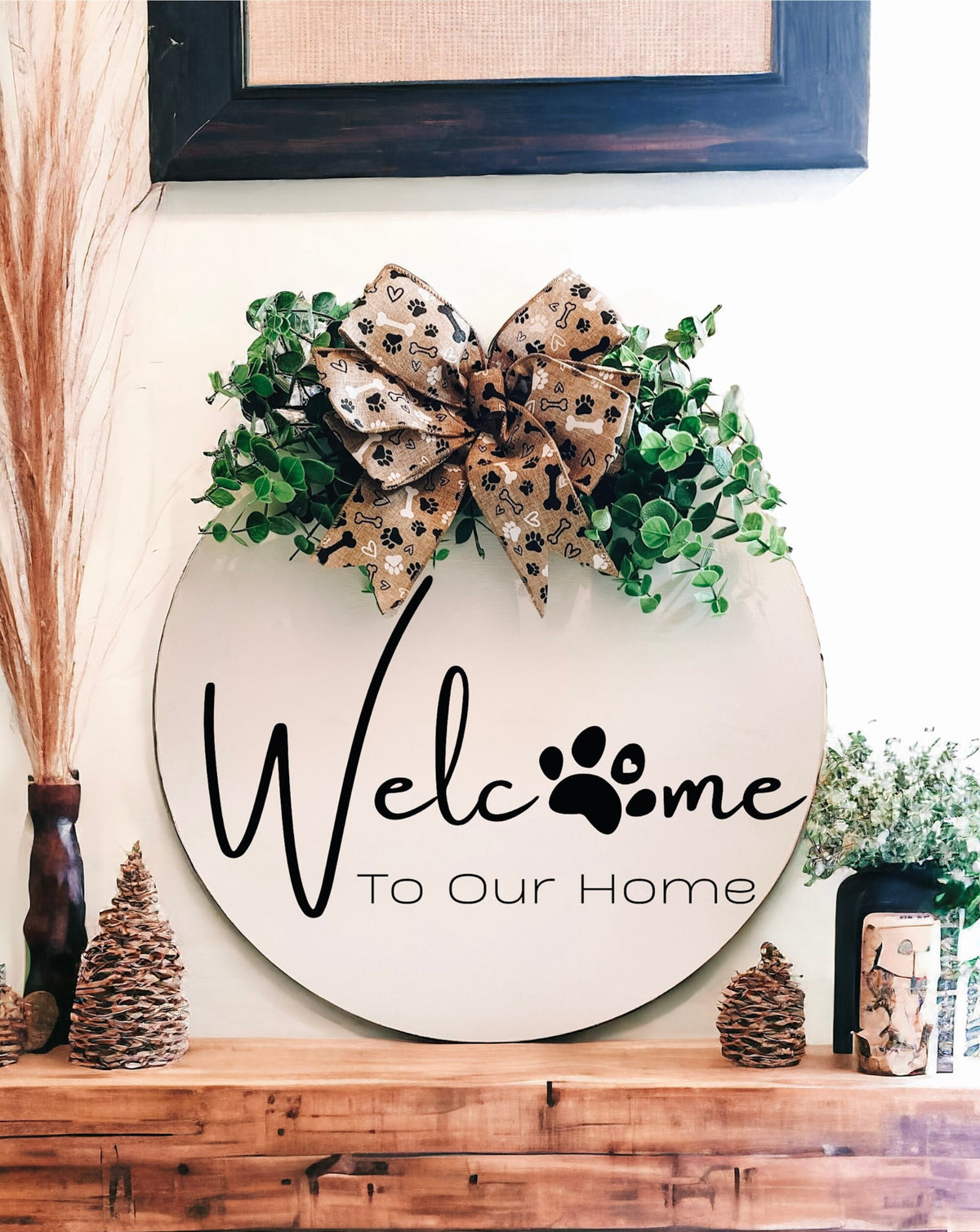 Welcome paw print door hanger on rustic wood mantle with pine cones and dried grasses
