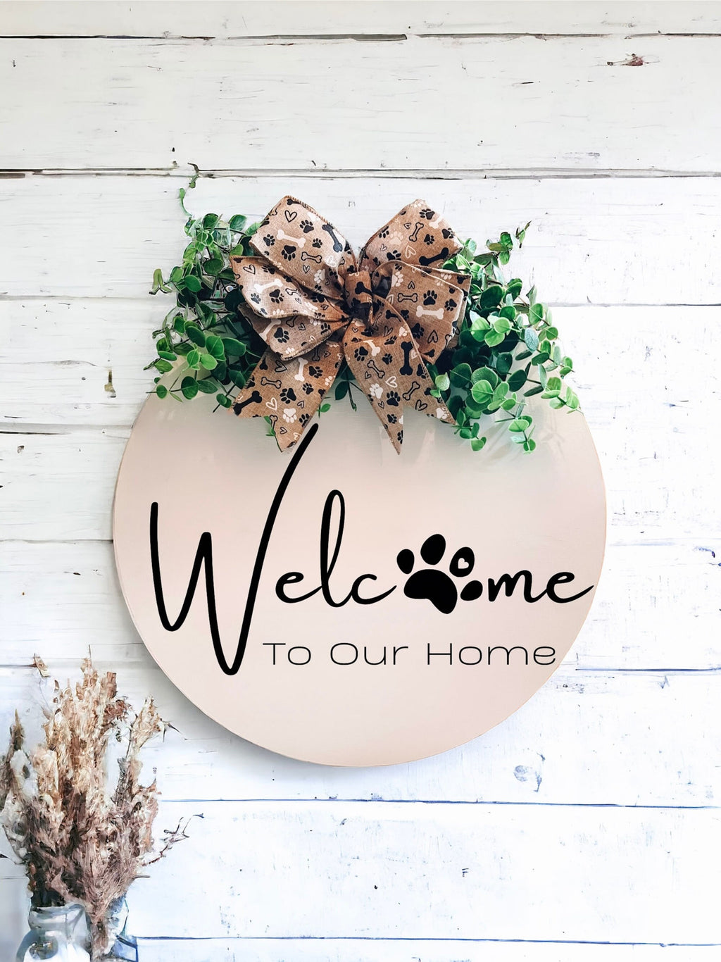 Welcome paw print door hanger on white shiplap wall with dried flowers